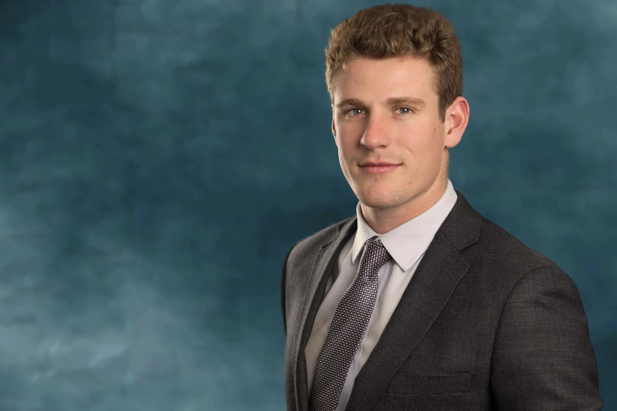 Corporate headshot of a businessman on a teal studio backdrop, Sydney