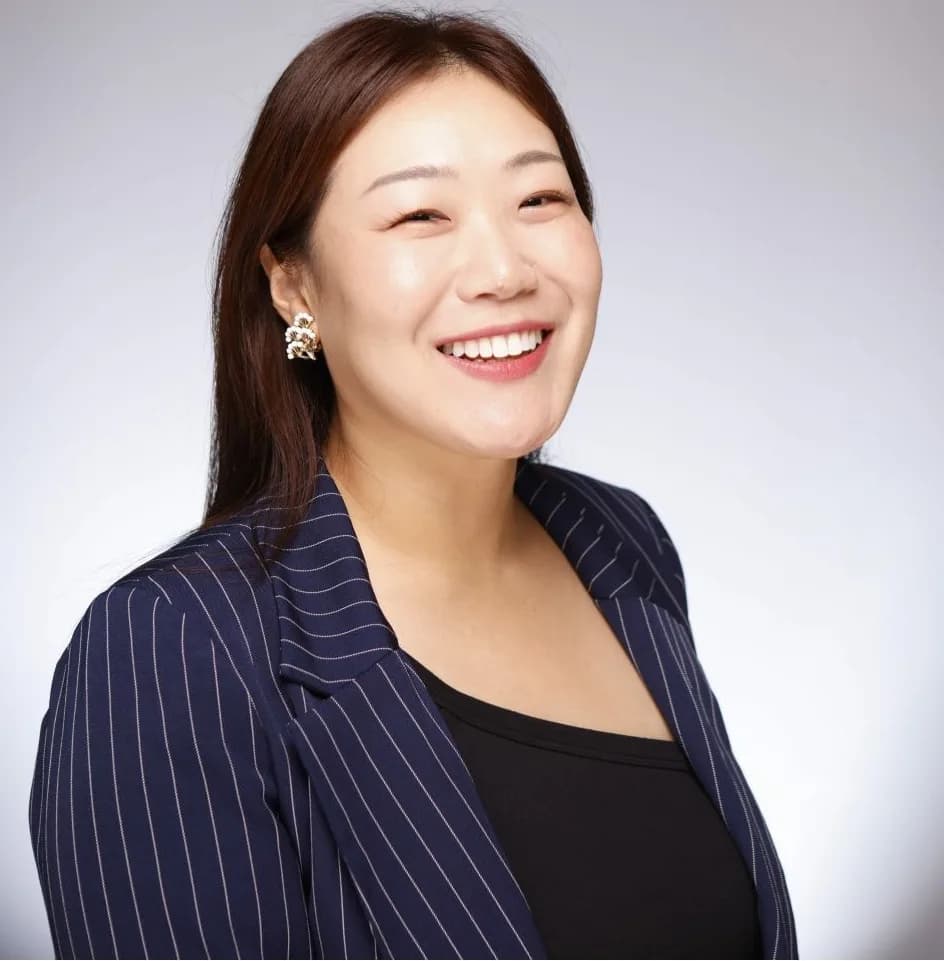 Corporate headshot of a woman in a pinstripe blazer, white background