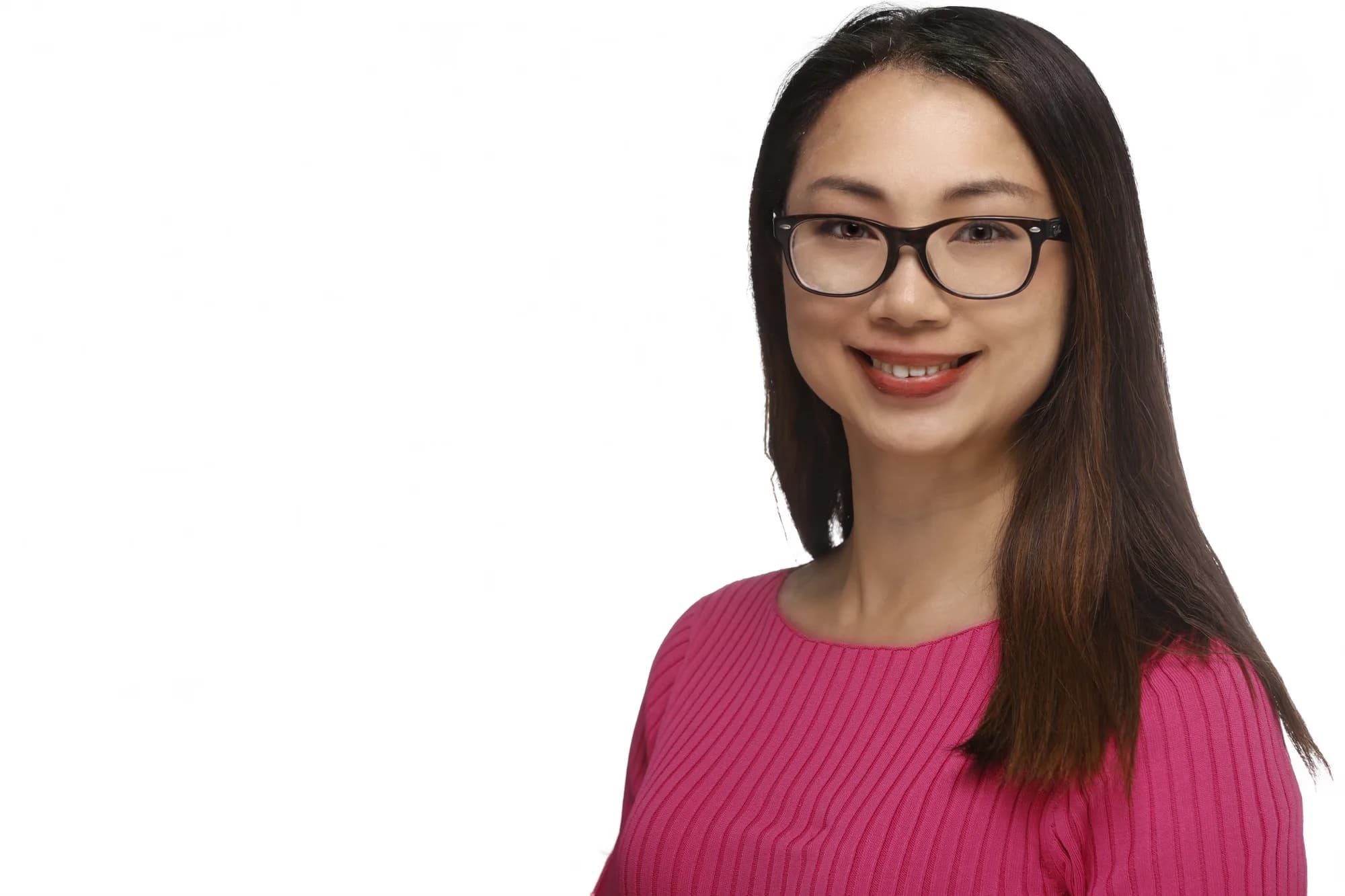 Corporate headshot of a woman in pink wearing glasses, white background
