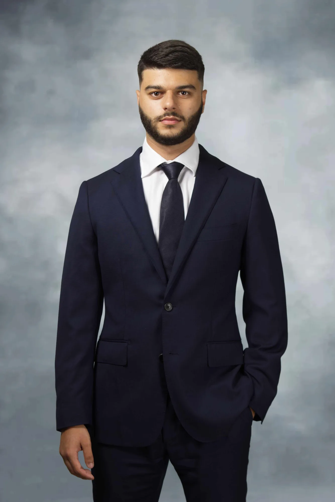 Corporate portrait of a man in a navy suit on a blue-grey backdrop, Sydney
